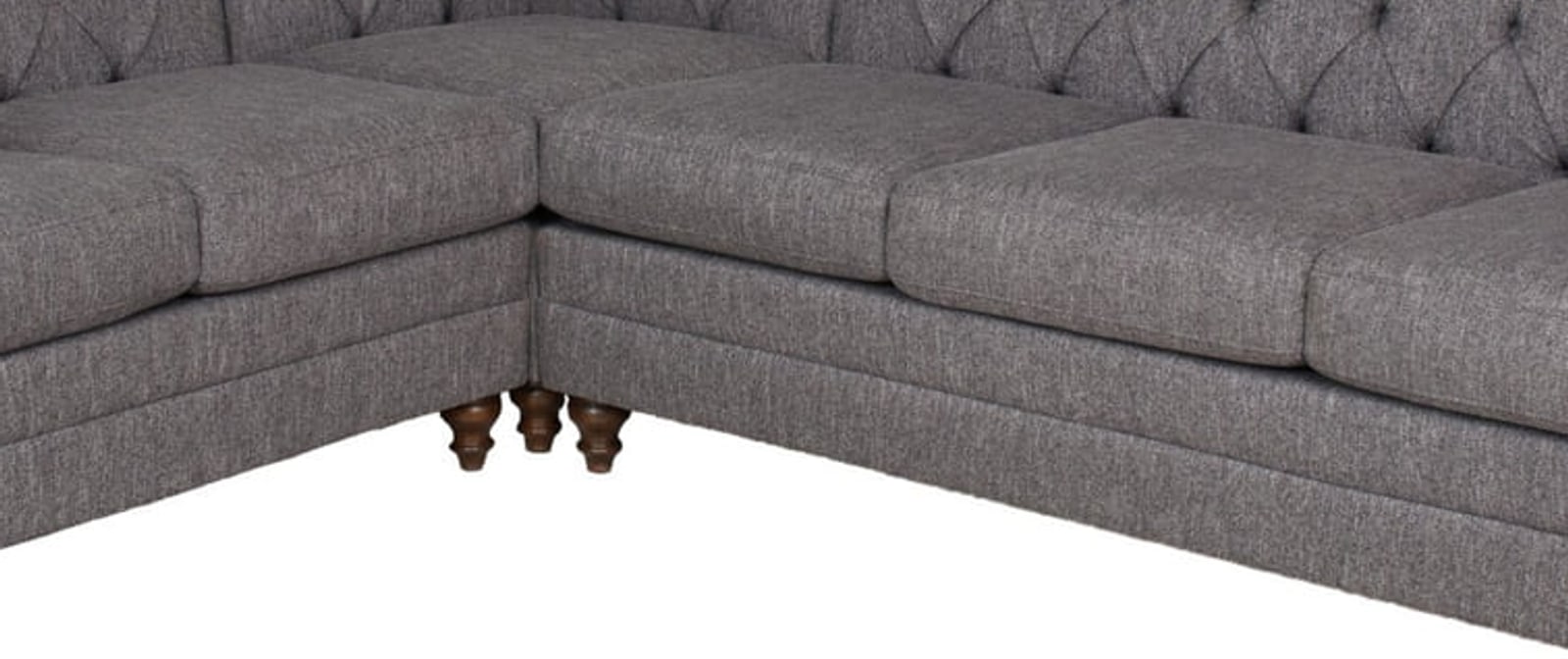 Close detail of a tufted sectional showing the buttoning, weave and turned wooden legs